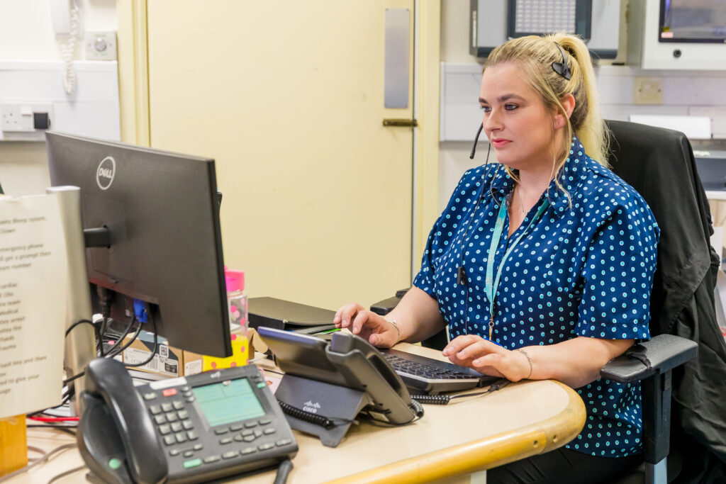 Switchboard operator wearing a headset sitting at her desk